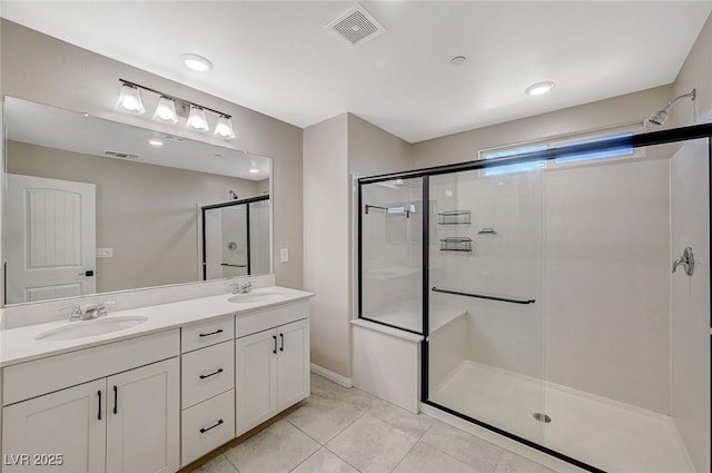 bathroom with visible vents, a shower stall, and a sink