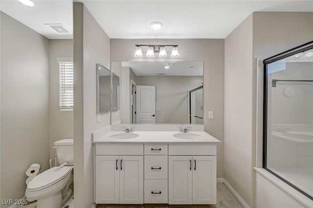 full bath with toilet, visible vents, a shower with shower door, and a sink