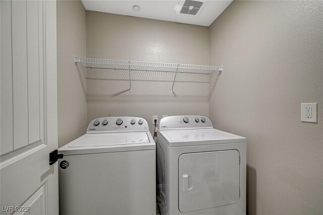 washroom featuring laundry area, washing machine and dryer, and visible vents