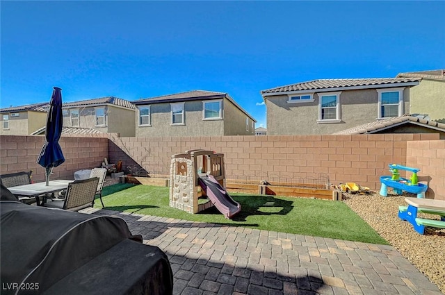 view of patio featuring a playground and a fenced backyard