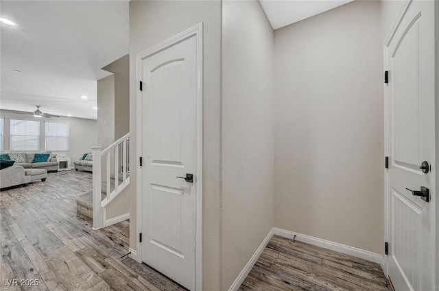 corridor featuring stairway, recessed lighting, baseboards, and wood finished floors