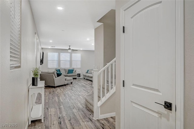 hall featuring recessed lighting, stairs, light wood-type flooring, and baseboards