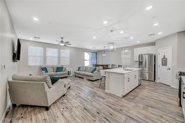 living area featuring a ceiling fan, recessed lighting, visible vents, and light wood-type flooring