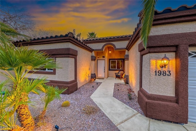 view of front facade featuring stucco siding and a tile roof