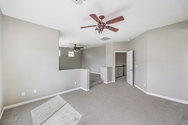 empty room featuring light carpet, a ceiling fan, and baseboards