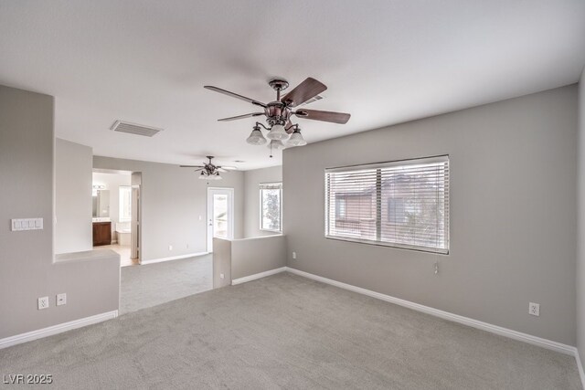 carpeted empty room with a ceiling fan and baseboards