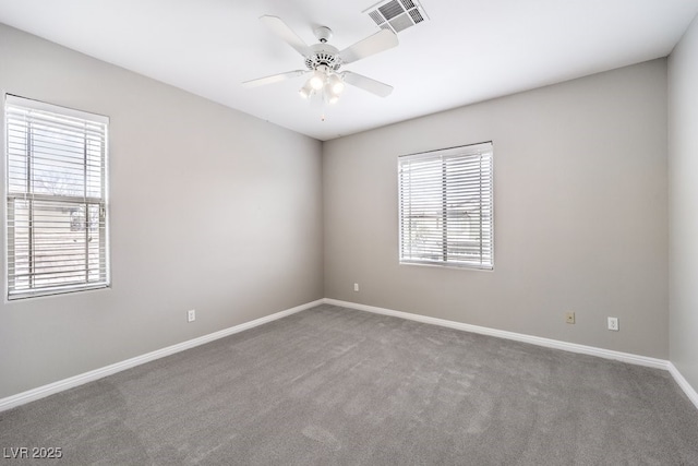 spare room featuring plenty of natural light, carpet floors, and baseboards