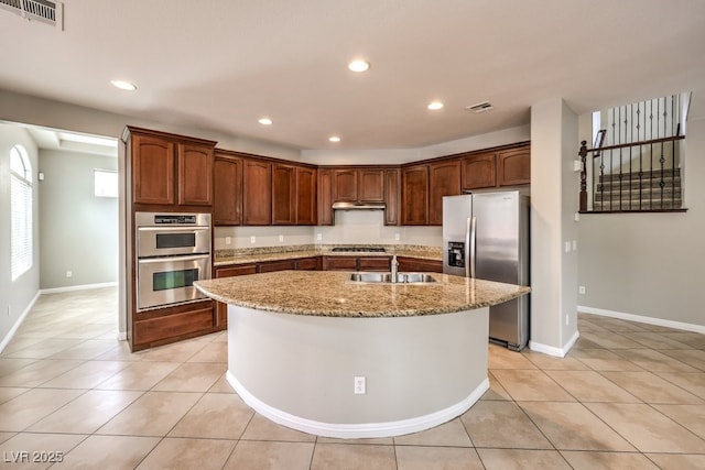 kitchen featuring stainless steel appliances, a sink, under cabinet range hood, light stone countertops, and recessed lighting