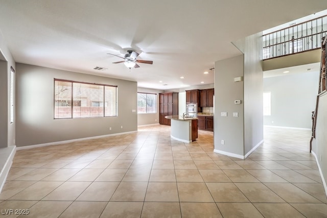 unfurnished living room with ceiling fan, light tile patterned flooring, baseboards, and recessed lighting