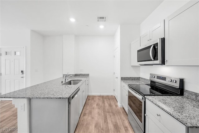 4125 Venus Falls Ave, North Las Vegas, NV 89084 - kitchen with stainless steel appliances, a peninsula, light wood-type flooring, light stone counters, and recessed lighting
