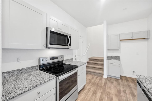 4125 Venus Falls Ave, North Las Vegas, NV 89084 - kitchen featuring stainless steel appliances, light stone counters, and light wood-style floors
