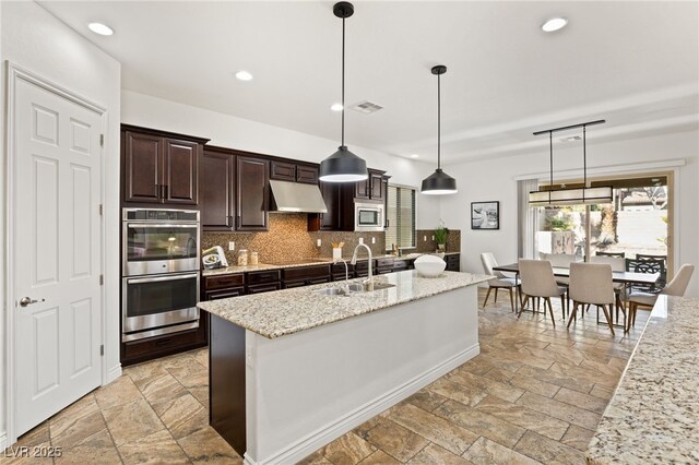 50 Carolina Cherry Dr, Las Vegas, NV 89141 - kitchen with stainless steel appliances, stone tile floors, under cabinet range hood, backsplash, and recessed lighting