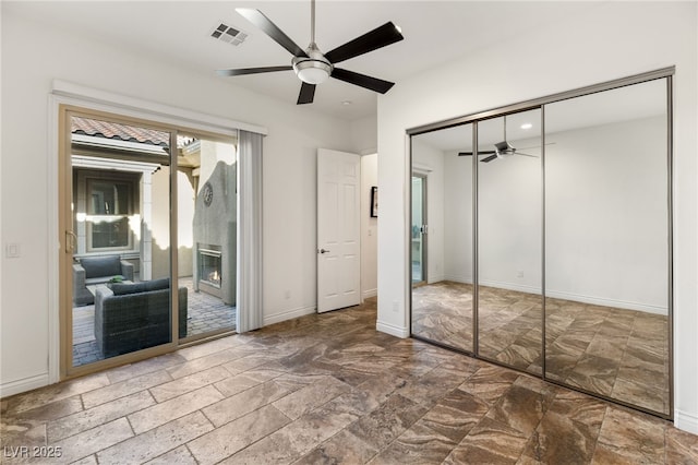 50 Carolina Cherry Dr, Las Vegas, NV 89141 - unfurnished bedroom featuring access to outside, stone finish flooring, a ceiling fan, and a closet