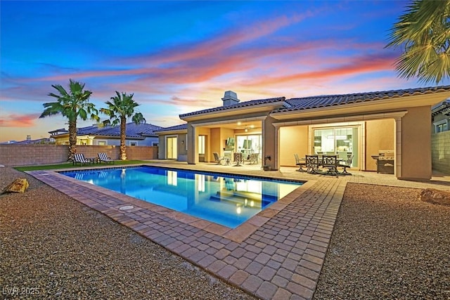 50 Carolina Cherry Dr, Las Vegas, NV 89141 - pool at dusk with a fenced backyard, a patio, outdoor dining space, and area for grilling