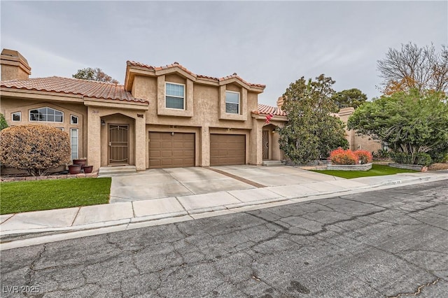 mediterranean / spanish home featuring stucco siding, a tile roof, concrete driveway, an attached garage, and a chimney