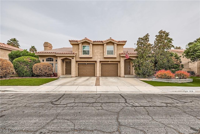 mediterranean / spanish-style home with concrete driveway, a tile roof, stucco siding, a chimney, and an attached garage