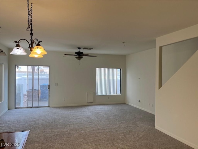 unfurnished room with carpet flooring, visible vents, a wealth of natural light, and ceiling fan