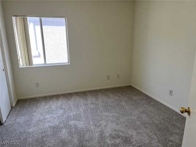 carpeted spare room featuring baseboards