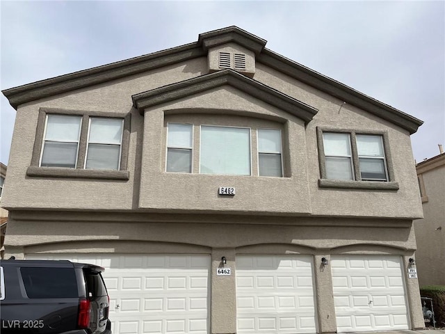 view of side of home with stucco siding and a garage