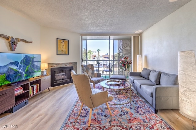 725 N Royal Crest Cir Unit 227, Las Vegas, NV 89169 - living area with a textured ceiling, wood finished floors, a fireplace, and expansive windows