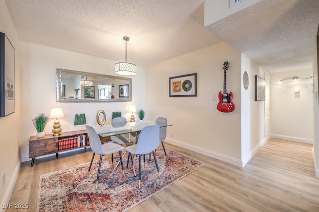 725 N Royal Crest Cir Unit 227, Las Vegas, NV 89169 - dining room featuring a textured ceiling, wood finished floors, and baseboards