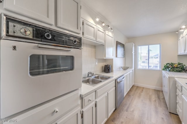 725 N Royal Crest Cir Unit 227, Las Vegas, NV 89169 - kitchen featuring washing machine and dryer, decorative backsplash, light countertops, dishwasher, and a sink