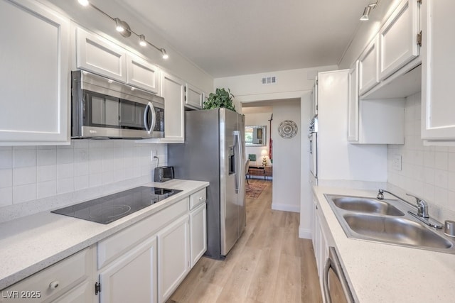 725 N Royal Crest Cir Unit 227, Las Vegas, NV 89169 - kitchen with stainless steel appliances, a sink, white cabinets, light wood-type flooring, and light countertops