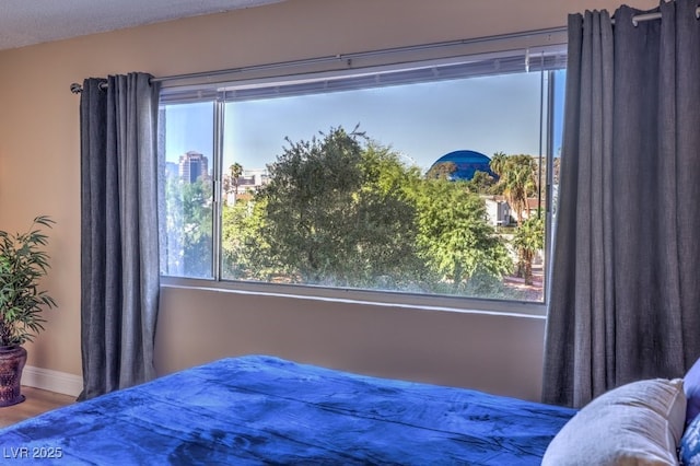 725 N Royal Crest Cir Unit 227, Las Vegas, NV 89169 - bedroom with multiple windows, wood finished floors, and baseboards