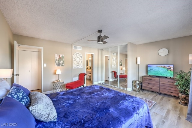 725 N Royal Crest Cir Unit 227, Las Vegas, NV 89169 - bedroom with wood finished floors, baseboards, a textured ceiling, a ceiling fan, and connected bathroom