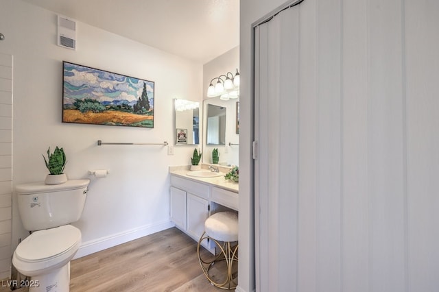 725 N Royal Crest Cir Unit 227, Las Vegas, NV 89169 - bathroom with wood finished floors, toilet, baseboards, and vanity