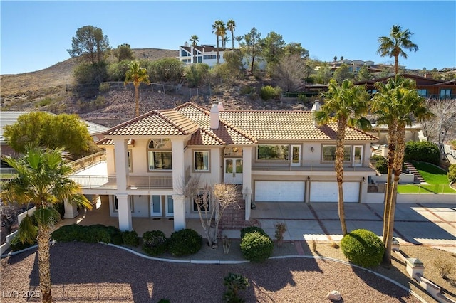 380 Claremont St, Boulder City, NV 89005 - mediterranean / spanish-style house with a tile roof, a chimney, concrete driveway, an attached garage, and stucco siding