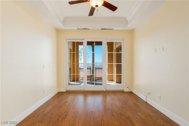 26 Via Vasari Unit 204, Henderson, NV 89011 - unfurnished room with crown molding, a tray ceiling, wood finished floors, and a ceiling fan