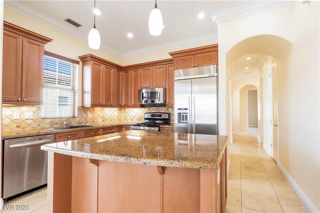 26 Via Vasari Unit 204, Henderson, NV 89011 - kitchen with appliances with stainless steel finishes, light tile patterned flooring, decorative backsplash, arched walkways, and ornamental molding