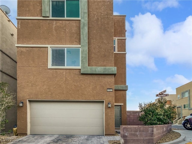 10537 Headwind Ave, Las Vegas, NV 89129 - view of front of house with a garage, stucco siding, and driveway