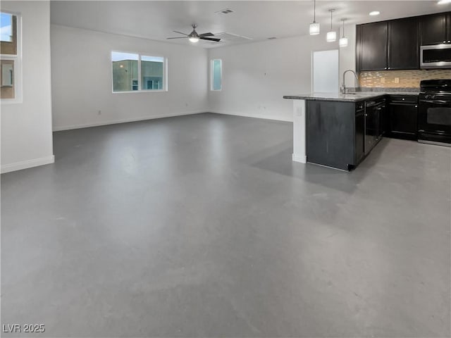 10537 Headwind Ave, Las Vegas, NV 89129 - kitchen featuring black range with gas stovetop, stainless steel microwave, decorative backsplash, open floor plan, and finished concrete flooring