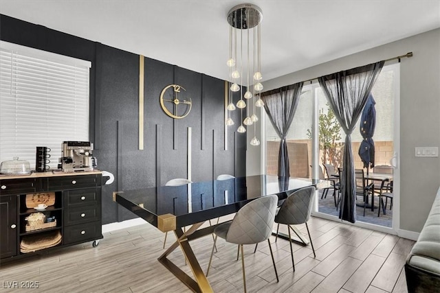 dining space featuring light wood finished floors and baseboards