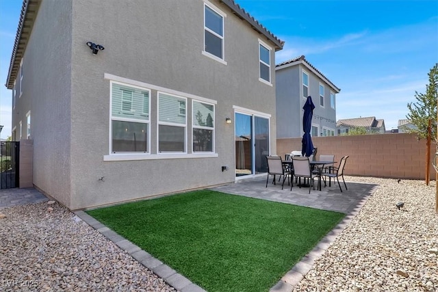 back of house featuring stucco siding, a lawn, a patio area, fence, and a tile roof