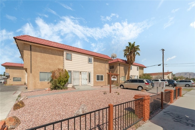 2915 Cedar Ave Unit 12C, Las Vegas, NV 89101 - view of front facade featuring stucco siding, a tile roof, and fence