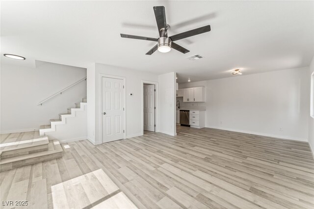 2915 Cedar Ave Unit 12C, Las Vegas, NV 89101 - unfurnished living room featuring visible vents, a ceiling fan, light wood-style floors, baseboards, and stairs