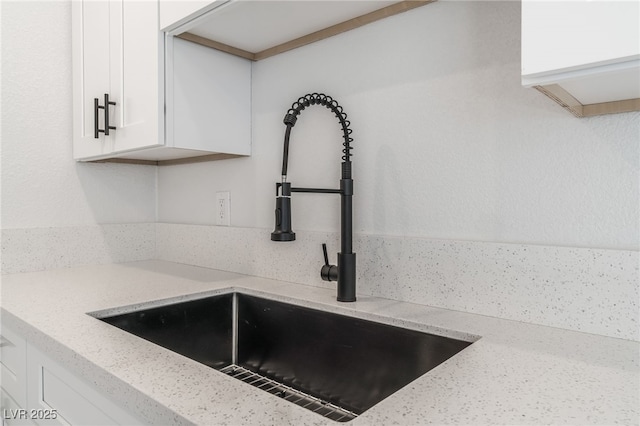 2915 Cedar Ave Unit 12C, Las Vegas, NV 89101 - interior details featuring a sink, light stone countertops, and white cabinets