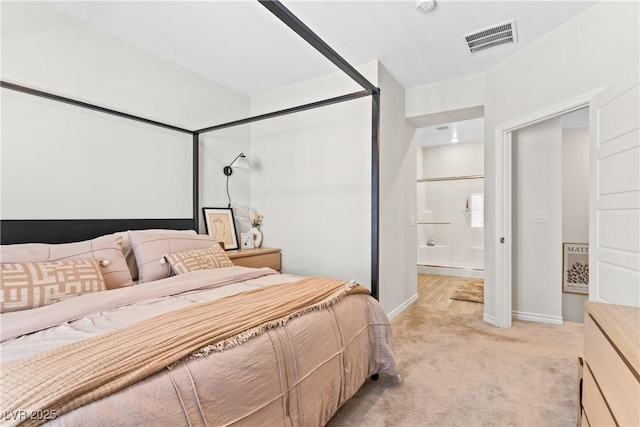 bedroom featuring light carpet, baseboards, and ensuite bathroom
