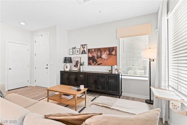 living room with wood finished floors, baseboards, and recessed lighting