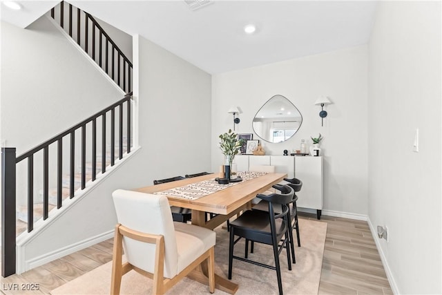 dining room featuring stairs, light wood-style flooring, baseboards, and recessed lighting
