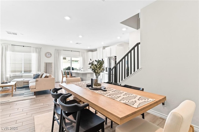 dining area featuring light wood-style floors, stairs, recessed lighting, and baseboards