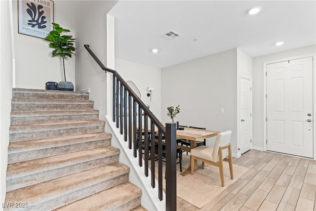 stairway featuring recessed lighting, wood finished floors, and baseboards