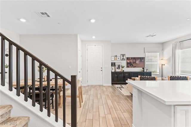 staircase with wood finished floors, recessed lighting, and baseboards