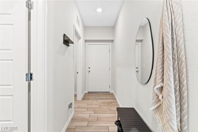corridor featuring light wood-style floors, baseboards, and recessed lighting