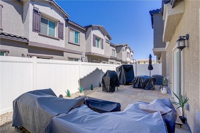 view of patio featuring a residential view, a fenced backyard, and central AC