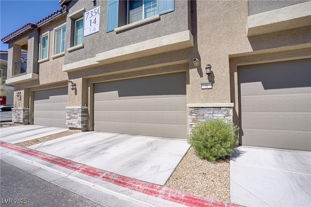 view of front of home with stone siding, stucco siding, a garage, and concrete driveway