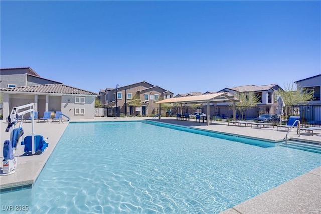 community pool with a gazebo, fence, a residential view, and a patio